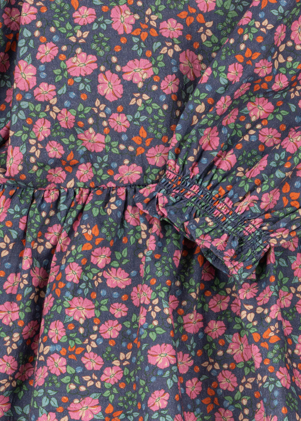 Close-up of the Girls' Cianna Blouse by Konges Slojd, featuring woven cotton with a multicolored floral print and gathered elastic details for a stylish crinkle effect.