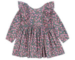 The Girls' Cianna Bow Dress by Konges Slojd is a long-sleeve organic cotton dress with a pink floral print on a dark background, featuring frill sleeves, ruffled shoulders, and a gathered waist.