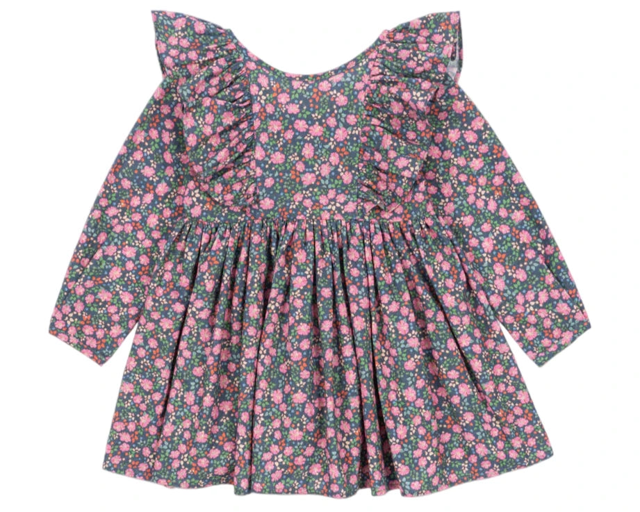 The Girls' Cianna Bow Dress by Konges Slojd is a long-sleeve organic cotton dress with a pink floral print on a dark background, featuring frill sleeves, ruffled shoulders, and a gathered waist.