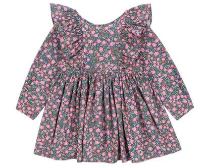 The Girls' Cianna Bow Dress by Konges Slojd is a long-sleeve organic cotton dress with a pink floral print on a dark background, featuring frill sleeves, ruffled shoulders, and a gathered waist.