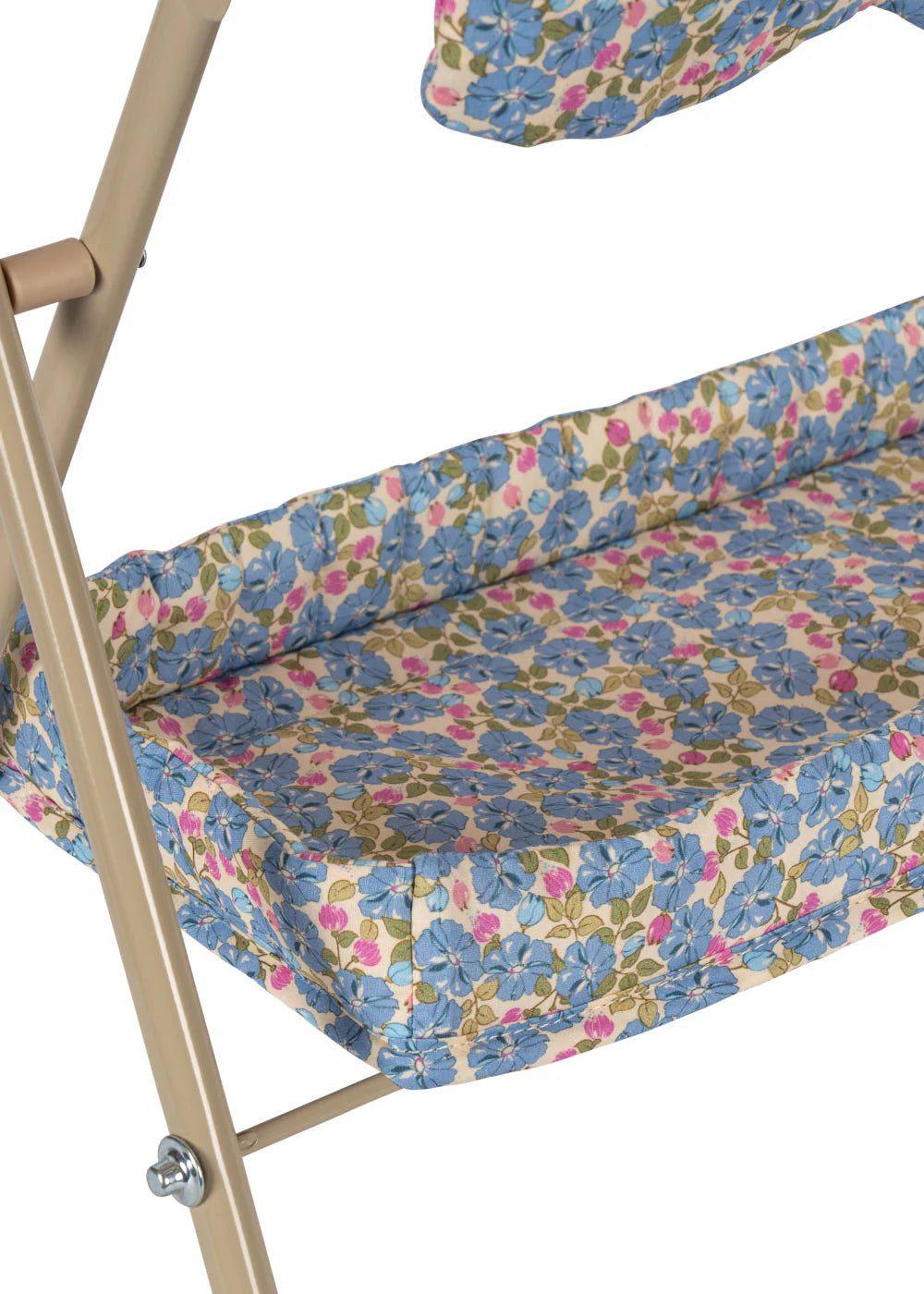 A close-up of the Konges Slojd Doll Changing Table, featuring a beige metal frame, floral-patterned cushion with blue, pink, and green flowers, and convenient storage pockets on the side.