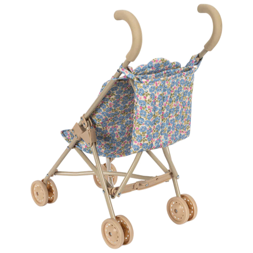 The Konges Slojd Doll Stroller is shown from a rear-side angle, featuring beige handles, double wheels, and a blue floral-patterned fabric seat and backrest.