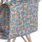 A close-up of the Konges Slojd Doll Stroller shows its blue, pink, and green floral fabric storage pocket, with a beige frame and double wheels partly visible.
