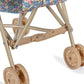 Close-up of the lower part of the Konges Slojd Doll Stroller, featuring double wheels and a beige floral-patterned fabric covering.