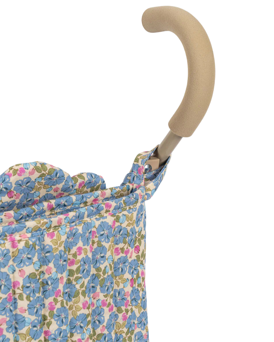 Close-up of a beige foam handle on the Konges Slojd Doll Stroller, shown with blue and pink floral fabric, showcasing the elegant design.