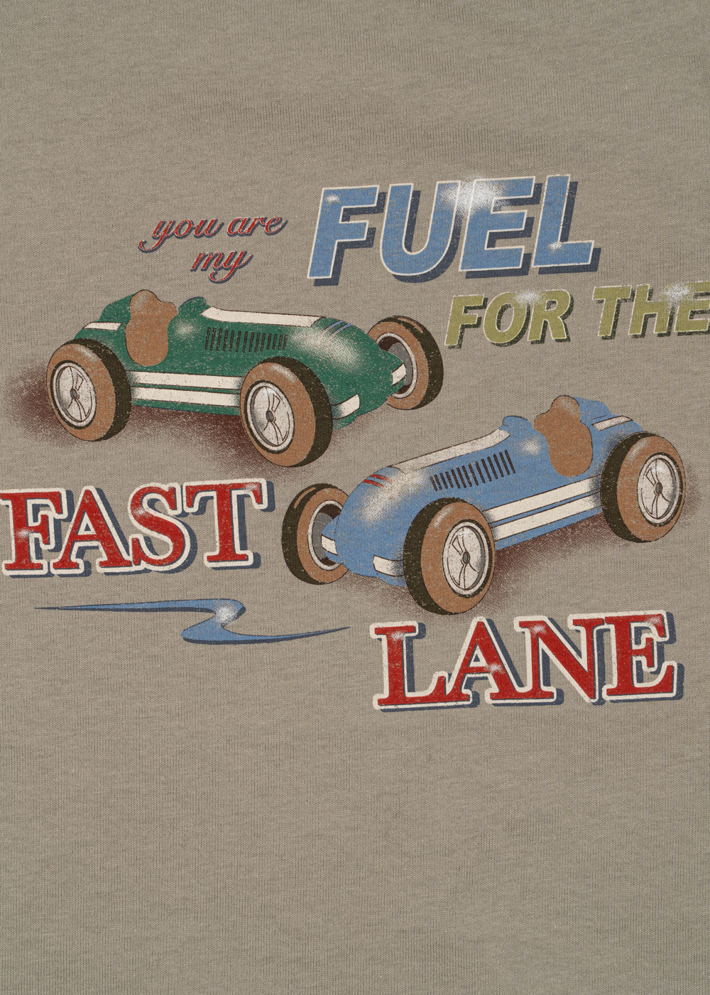 The Konges Slojd Baby Boys' and Boys' Drey Tee features two cartoon race cars, green and blue, racing on beige with "you are my FUEL FOR THE FAST LANE"—a playful, organic cotton shirt perfect for kids.