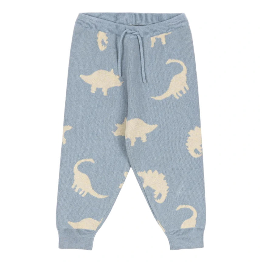 Konges Slojd Baby Boys' and Boys' Lapis Knit Pants feature a light blue jacquard knit with an elastic waist, drawstring, relaxed fit, and beige dinosaur silhouettes throughout.