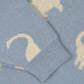The Konges Slojd Baby Boys' and Boys' Lapis Knit Sweater features a relaxed fit in blue with white dinosaur silhouettes, ribbed cuffs, and rib hems.