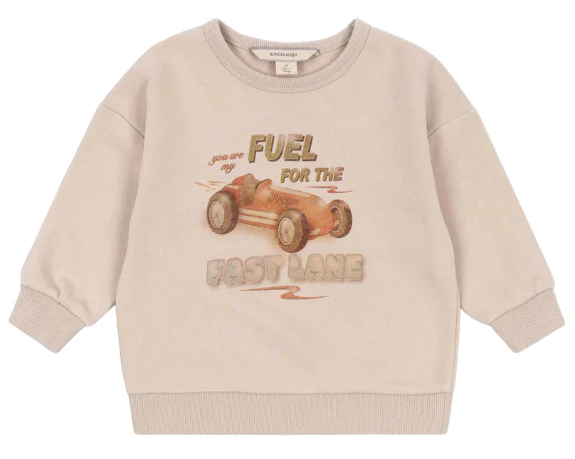 The Konges Slojd Baby Boys' and Boys' Lou Sweat Shirt is made from organic cotton, featuring ribbed cuffs and a vintage race car print with the text "Fuel for the fast lane.