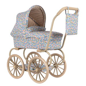 The Konges Slojd Minnie Doll Pram features a vintage style with quilted floral print fabric, a beige frame, large spoked wheels, foldable sun canopy, and a matching bag hanging from the handle.