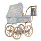 The Minnie Doll Pram by Konges Slojd is a vintage-style foldable stroller featuring large beige wheels, blue floral-patterned fabric, a canopy, and a matching bag—perfect for imaginative play.
