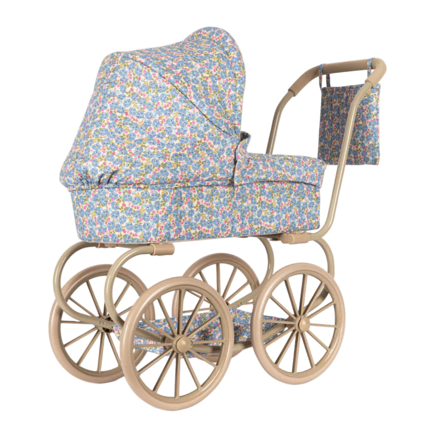 The Minnie Doll Pram by Konges Slojd is a vintage-style foldable stroller featuring large beige wheels, blue floral-patterned fabric, a canopy, and a matching bag—perfect for imaginative play.