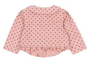 The Konges Slojd Baby Girls' and Girls' Nola Sequin Shirt Jacket is shown from the back, featuring light pink fabric, long sleeves, a Peter Pan collar, red heart pattern, and frill hems along the bottom.