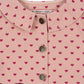 Close-up of the Konges Slojd Baby Girls' and Girls' Nola Sequin Shirt Jacket, a pink cotton twill design with a rounded collar, pink buttons, and small dark pink heart pattern. The label reads "konges sløjd.