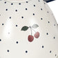 Cream-colored teapot from the Konges Slojd Blue Dot Tea Party Set, featuring small blue polka dots and a red cherry illustration.