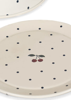 Off-white plates from the Konges Slojd Blue Dot Tea Party Set, featuring blue polka dots and a small cherry illustration in the center.