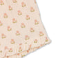 Light pink fabric adorned with a repeating pattern of small pink flowers and green leaves, finished with a ruffled edge at the bottom right corner—ideal for crafting airy and comfortable shorts like the Konges Slojd Baby Girls’ and Girls’ Coco Shorts, which feature an elastic waist for added comfort.