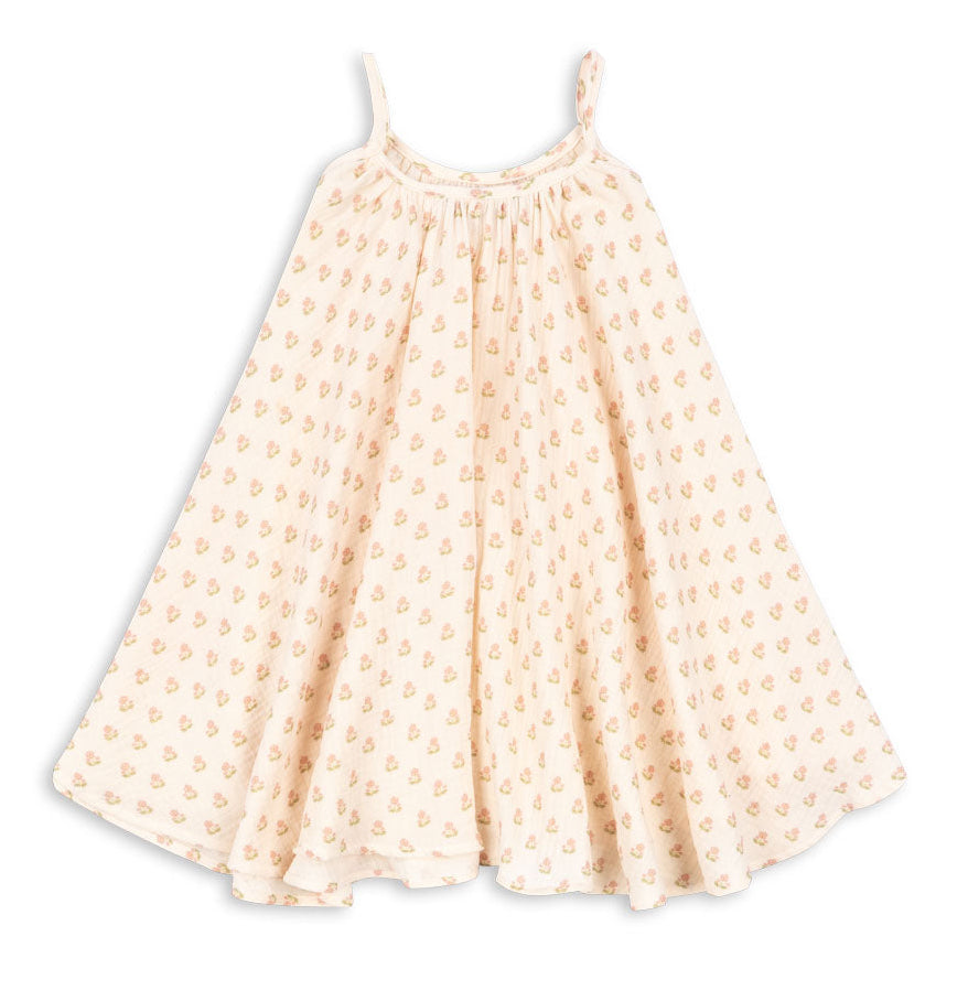 The Girls’ Coco Strap Dress by Konges Slojd is a sleeveless, cream-colored summer dress with thin straps and a loose, flared skirt, adorned with a delicate pink floral pattern throughout. This soft dress offers an easy, breezy style that’s perfect for warm days.