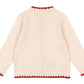 The Girls' Collette Cardigan by Konges Slojd is a cream-colored, long-sleeve knit with red scalloped trim on the collar, cuffs, and hem, plus strawberry embroidery on the elbows. Shown from the back.