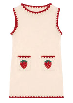 The Girls' Collette Dress by Konges Slojd is a sleeveless, cream knitted wool dress with a fitted silhouette, red trim, and two front pockets adorned with charming strawberry embroidery.