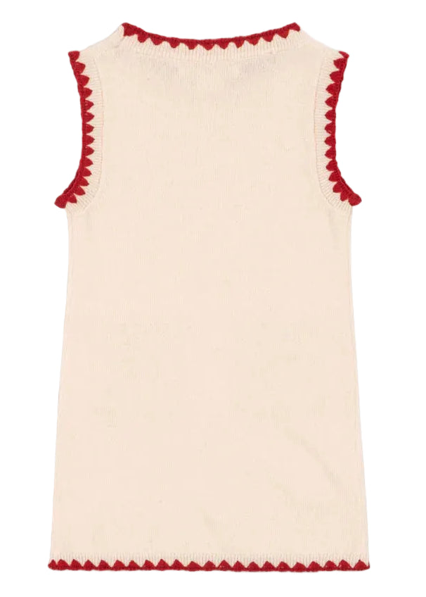 The Girls' Collette Dress by Konges Slojd is a sleeveless cream knitted wool dress with a fitted silhouette and red scalloped trim on the neckline, armholes, and hem, shown laid flat and photographed from the back.