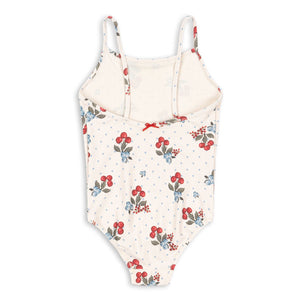 The Konges Slojd Baby Girls’ and Girls’ Frago Swimsuit features a cream base adorned with red strawberries, green leaves, blue dots, and a delicate red bow at the neckline. Designed for comfort and flexibility, this one-piece swimsuit ensures your little one can move freely during hours of play.