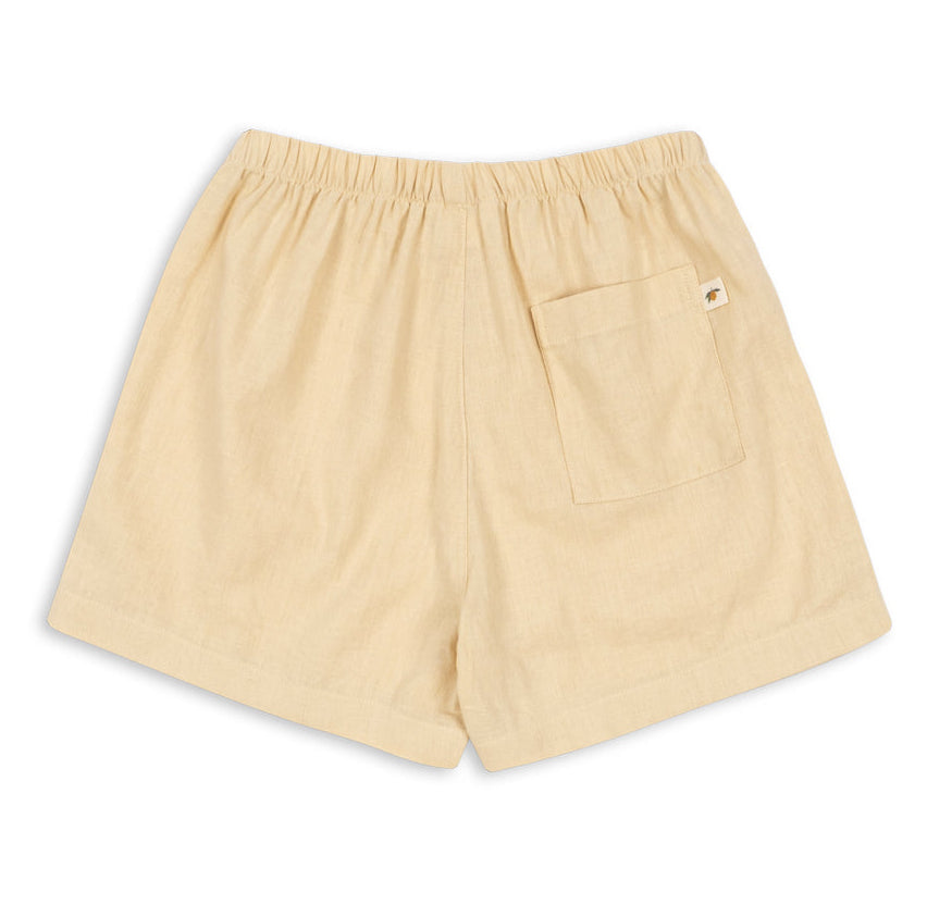 Konges Slojd Baby Boys’ and Boys’ Franzen Linen Shorts in beige, featuring an elastic waistband and a single back pocket, displayed flat on a white background.