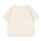 The Konges Slojd Baby Boys’ Itty Tee, a short-sleeved off-white t-shirt crafted from organic cotton terry, is displayed laid flat with the back facing up against a white background.