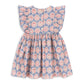 The Baby Girls’ and Girls’ Kim Frill Dress by Konges Slojd is a charming summer dress for children, featuring ruffled sleeves and a pink and blue floral pattern, shown here from the back.