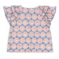 Back view of the Konges Slojd Baby Girls’ and Girls’ Kim Frill Shirt, a short-sleeved top featuring blue and pink floral and teacup patterns with frill detailing on the ruffled sleeves.