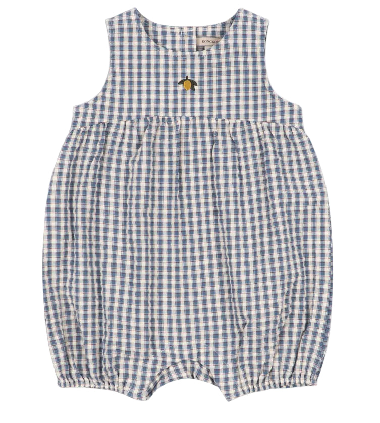 The Baby Kim Romper by Konges Slojd features a sleeveless design in a blue and white checkered seersucker fabric, a gathered waist, delicate elastic cuffs for extra comfort, snap buttons at the bottom, and is adorned with a small embroidered yellow flower.
