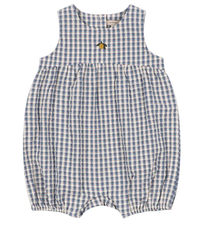 The Baby Kim Romper by Konges Slojd features a sleeveless design in a blue and white checkered seersucker fabric, a gathered waist, delicate elastic cuffs for extra comfort, snap buttons at the bottom, and is adorned with a small embroidered yellow flower.