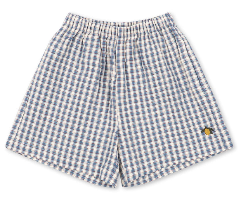 Baby boys’ and boys’ Kim Short by Konges Slojd, featuring a blue and white checkered design, crafted from breathable organic cotton with an elastic waistband and a small yellow embroidered detail on the lower right leg, laid flat on a white background.