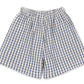 Baby Boys’ and Boys’ Kim Shorts by Konges Slojd, featuring a blue and white checkered pattern with an elastic waistband, crafted from breathable organic cotton for all-day comfort, displayed flat on a white background.