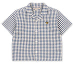 The Konges Slojd Baby Boys’ and Boys’ Kim Short Sleeve Shirt features a charming blue and white check seersucker pattern, crafted from soft organic cotton, and is finished with a small embroidered bee on the left chest.