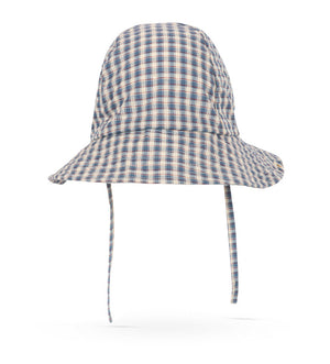 The Konges Slojd Baby Boys’ and Boys’ Sun Hat, featuring a blue and beige plaid pattern, is made from organic cotton and includes a wide brim and chin straps. It is displayed on a white background.