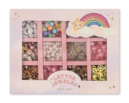 The ABC Jewelery Set by Konges Slojd features letter pearls, faux pearls, smiley faces, and gold beads in pastel rainbow star packaging with compartments.