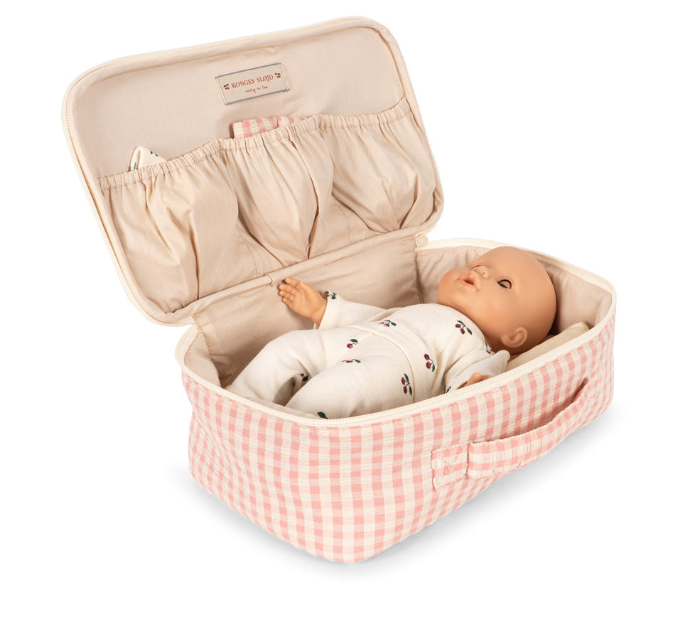 The Baby Doll Nursery Suitcase by Konges Slojd features a pink and white checked case with a soft doll and lid pockets for nursery accessories, perfect for imaginative play.