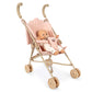A Poppy Doll Stroller Set featuring a Poppy doll with a pacifier sitting in a light pink gingham toy stroller with cherry embroidery.