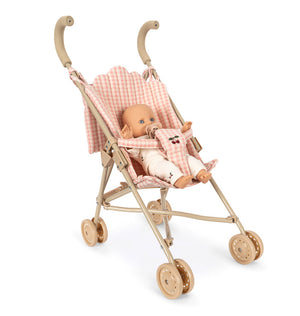 A Poppy Doll Stroller Set featuring a Poppy doll with a pacifier sitting in a light pink gingham toy stroller with cherry embroidery.