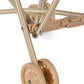 Close-up of the lower frame and wheels of the Sparkly Doll Stroller by Konges Slojd, showing intersecting metal bars and two plastic wheels on a white background.