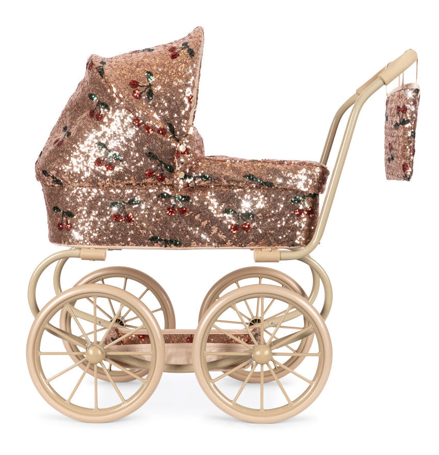Sparkly Minnie Doll Pram with a foldable sun canopy, covered in rose gold sequins and a red cherry pattern, featuring a light tan frame and large wheels.