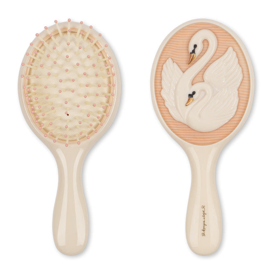 The Konges Slojd Swan Beauty Set features two beige hairbrushes—one with pink-tipped bristles, one with swan details—ideal for pairing with a hand mirror.