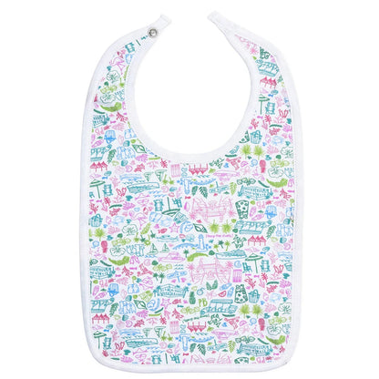 The Joy Street Palm Beach Bib by Joy Street is a white baby bib adorned with vibrant, iconic images of carousels, castles, and flowers, evoking the charm of Palm Beach.