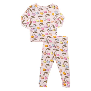 The Pink Chicken Kids' Bamboo PJ Set includes long-sleeve top and pants with a colorful cherry print on a light pink background.