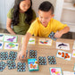 Two children play the Eeboo Memory Match & Make Card Game at a wooden table, enjoying matching cards that feature colorful illustrations of sea animals.