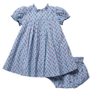 Pink Chicken Baby Girls’ Lucia Dress Set in light blue, featuring short puff sleeves and a delicate floral print, adorned with exquisite diamond smocking that highlights heritage craftsmanship. The set includes matching bloomers and is displayed on a white background.