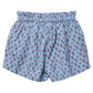 Girls’ Theodore Short by Pink Chicken in light blue, featuring a ruffled elastic waistband and decorated with a charming pattern of small red and green blockprint floral designs.