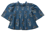 Pink Chicken Girls’ Jaipur Top features a floral pattern, pleated front, bell sleeves, ruffled collar, and navy glitter buttons for sparkle.