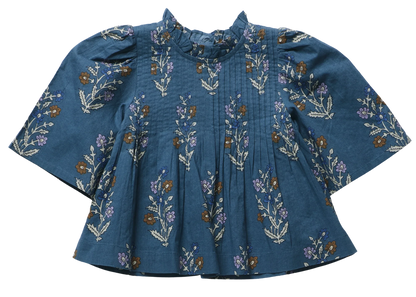 Pink Chicken Girls’ Jaipur Top features a floral pattern, pleated front, bell sleeves, ruffled collar, and navy glitter buttons for sparkle.